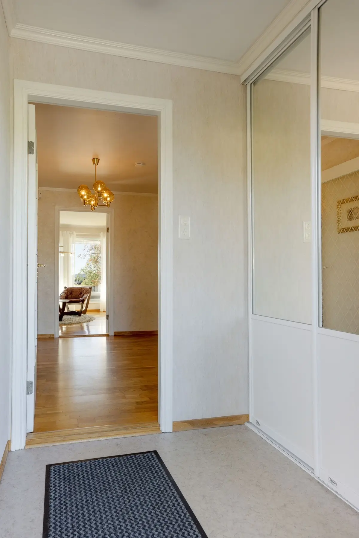 Lys entré med flott skyvedørsgarderobe.