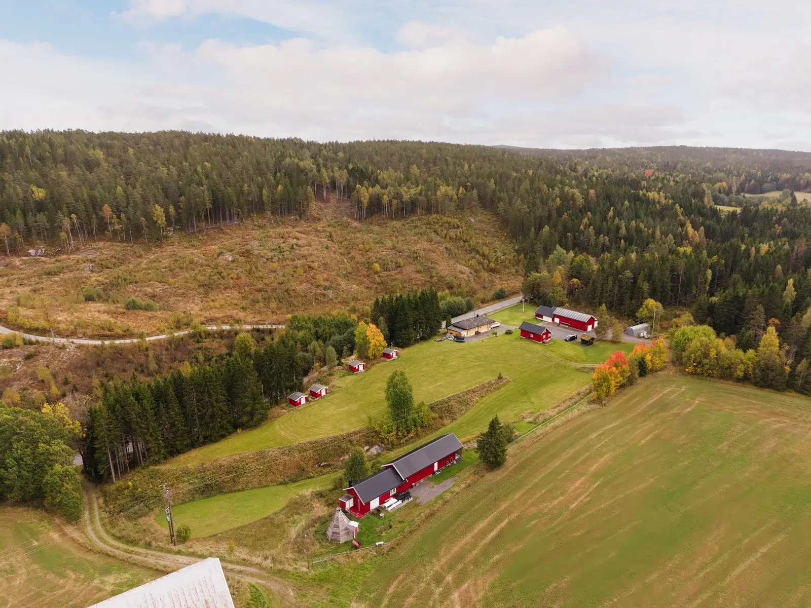Oversiktsbilde av eiendommen som er på rett over 14 mål totalt. I fremkant ser vi vognskjul og grillhytte, mens hovedhus